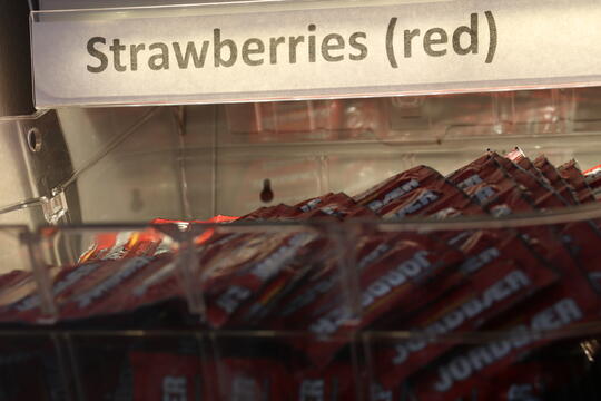 Et nærbilde av en skuff i kondomstativet i stua. Skuffen er fylt med røde kondomer av typen "jordbær".